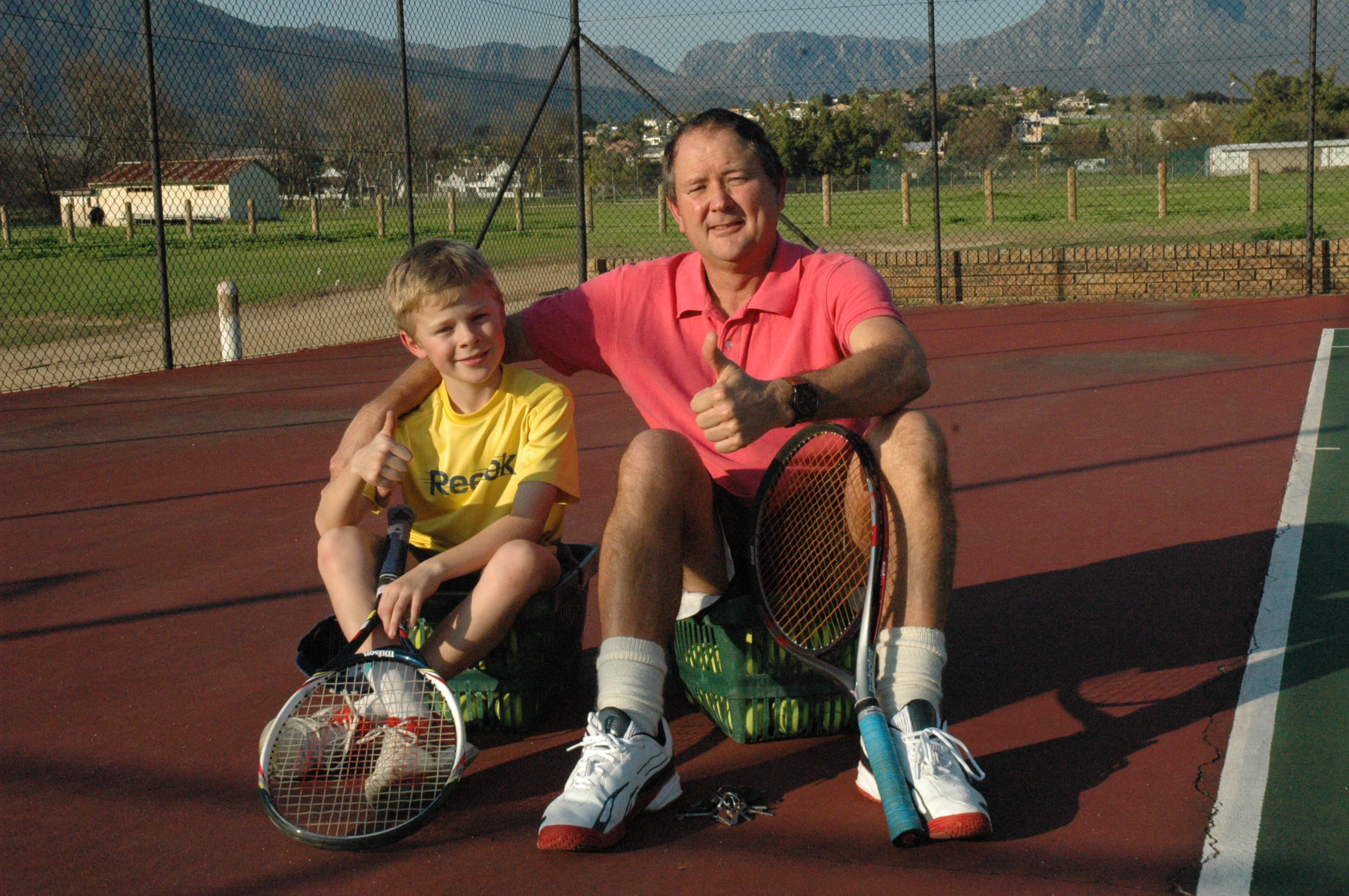 Coach Myburgh with a youbg tennis player enjoying the tennis coaching experience