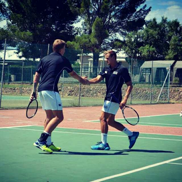 Boland Landbou first team players giving a high-five during a doubles match.